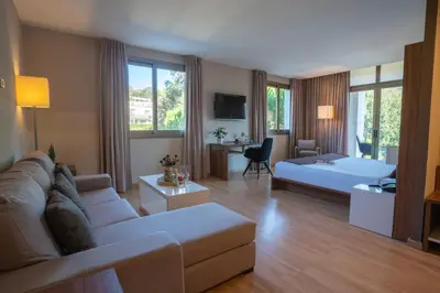 a large living room with a couch and a bed at Hotel & Spa Golden Barcelona in Vallromanas