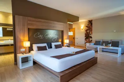 a bedroom with a large bed with a sign on the wall at Hotel & Spa Golden Barcelona in Vallromanas