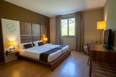 a hotel room with a large bed and a television at Hotel & Spa Golden Barcelona in Vallromanas
