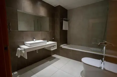 a bathroom with a sink and a toilet and a tub at Hotel & Spa Golden Barcelona in Vallromanas