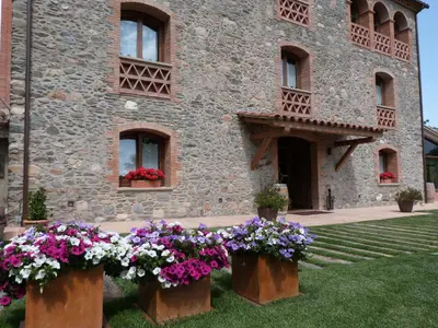 a building with flowers in front of it at Hotel Rural Can Vila in Sant Esteve de Palautordera