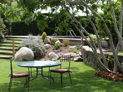 a table and two chairs in a garden at Hotel Rural Can Vila in Sant Esteve de Palautordera