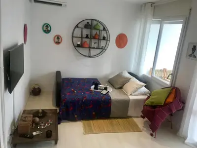 a bedroom with a bed and a chair and a mirror at Seaside Apartment in Sitges Steps from Beaches with private Patio in Sitges