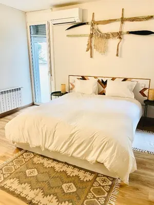 a bedroom with a large white bed with a large window at Seaside Apartment in Sitges Steps from Beaches with private Patio in Sitges