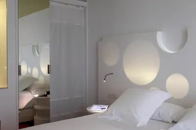 a bedroom with a white bed and a mirror at Room Mate Pau, Barcelona in Barcelona