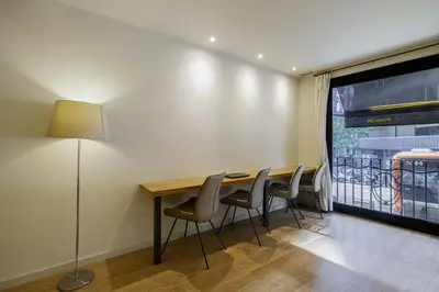 a dining room with a table and chairs and a window at Ola Living Diagonal Apartments in Barcelona
