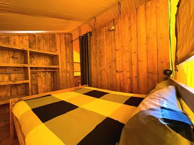 a bedroom with a bed with a yellow wall and a window at Càmping Parc Gualba in gualba de Dalt