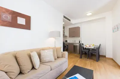 a living room with a couch and a kitchen at Matarolux16 in Mataró