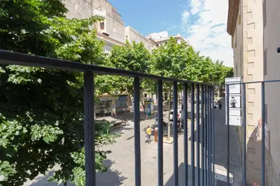 a view of a street with a fence and trees at Matarolux16 in Mataró