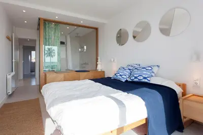 a bedroom with a large bed and a bathroom at Relaxing Seafront Apartment Gavà 20 Min from BCN in Gavà