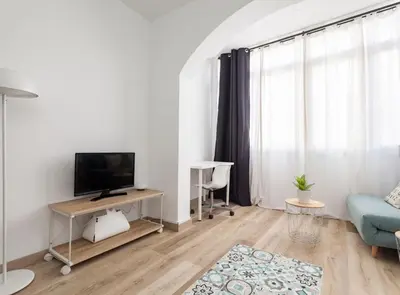 a living room with a tv and a blue couch at Siroco by Seaside Homes in Castelldefels