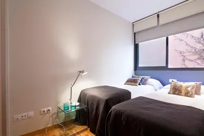 two beds in a room with a window at My Space Barcelona Guell Terrace Center in Barcelona