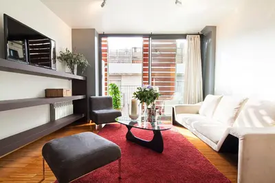 a living room with a white couch and a red rug at My Space Barcelona Guell Terrace Center in Barcelona