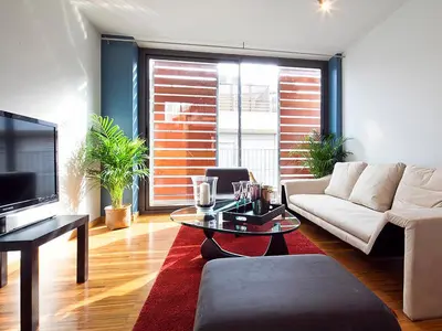 a living room with a couch and a tv at My Space Barcelona Guell Terrace Center in Barcelona