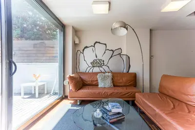 a living room with a leather couch and a glass table at My Space Barcelona Pool Garden Apartments in Barcelona