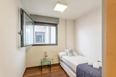 a small bedroom with a bed and a window at My Space Barcelona Pool Garden Apartments in Barcelona