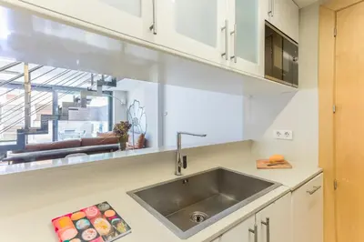 a kitchen with white cabinets and a sink at My Space Barcelona Pool Garden Apartments in Barcelona