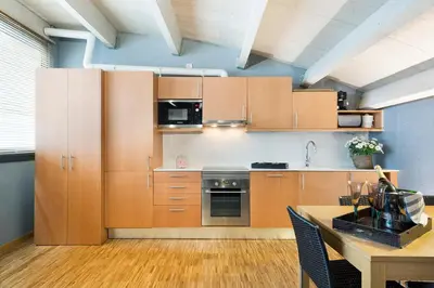 a kitchen with wooden cabinets and a wooden table at My Space Barcelona Executive Apartments Center in Barcelona