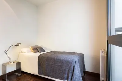 a bedroom with a bed with white sheets and a lamp at My Space Barcelona Executive Apartments Center in Barcelona