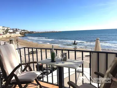 a building with umbrellas and tables in front of it at Apartment Alegria (Happy) in Sitges