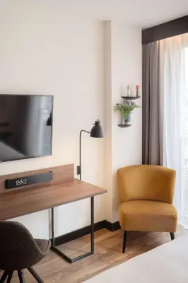 a living room with a desk and a tv and a chair at Radisson Blu 1882 Hotel, Barcelona Sagrada Familia in Barcelona