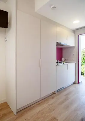 a room with white cabinets and a kitchen at Bellsol Rooms in Pineda de Mar