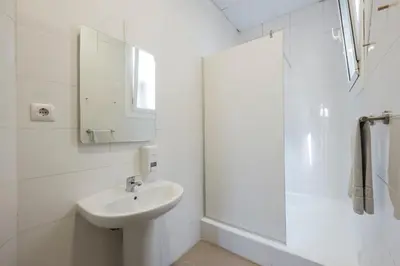 a white bathroom with a sink and a mirror at No Limit Hostel Graffiti in Barcelona