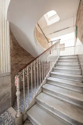 a spiral staircase in an old building with a window at No Limit Hostel Graffiti in Barcelona