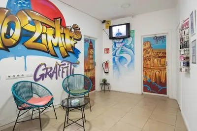 a room with two chairs and a wall with graffiti at No Limit Hostel Graffiti in Barcelona