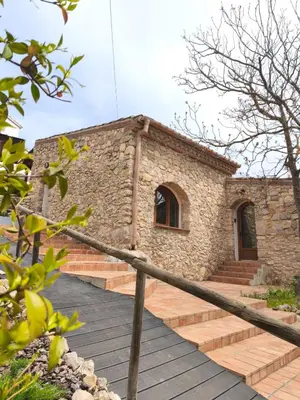 a stone building with stairs in front of it at Masía Cal Simó - Casa rural con piscina, cerca de Sitges, para celebraciones y eventos in Canyelles