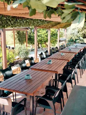 a long wooden table and chairs on a patio at Masía Cal Simó - Casa rural con piscina, cerca de Sitges, para celebraciones y eventos in Canyelles