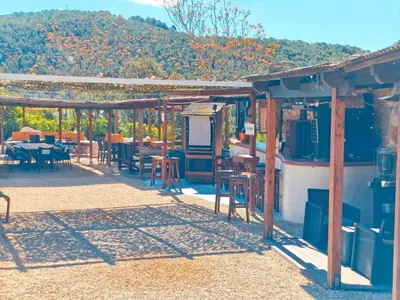 a patio with a table and chairs and a table and chairs at Masía Cal Simó - Casa rural con piscina, cerca de Sitges, para celebraciones y eventos in Canyelles
