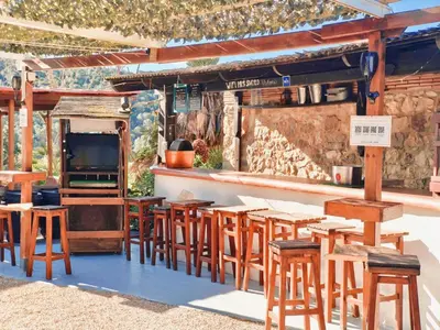 a bar with wooden tables and chairs and a tv at Masía Cal Simó - Casa rural con piscina, cerca de Sitges, para celebraciones y eventos in Canyelles