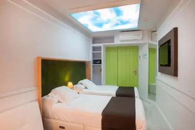 two beds in a room with a skylight at Hotel Ribes Roges in Vilanova i la Geltrú