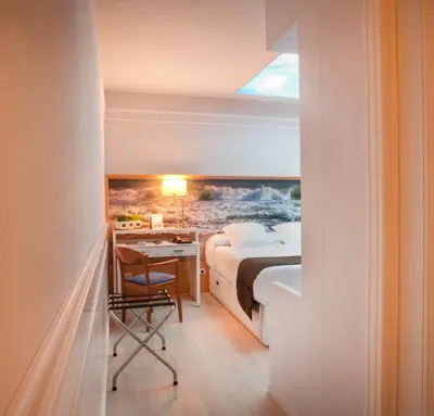 a bedroom with a bed and a desk with a desk at Hotel Ribes Roges in Vilanova i la Geltrú