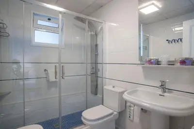 a bathroom with a toilet and a sink and a shower at Hotel Ribes Roges in Vilanova i la Geltrú