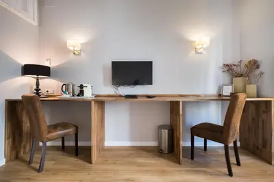 a wooden desk with two chairs and a television at Violeta Boutique in Barcelona