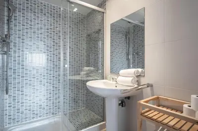 a bathroom with a sink and a glass shower at Rent Top Apartments Forum in Sant Adria de Besos