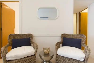 two wicker chairs and a table in a room at Novus Homes Barcelona Collblanc in Hospitalet de Llobregat