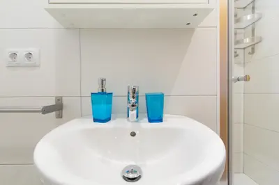 a bathroom sink with two blue glasses on it at Novus Homes Barcelona Collblanc in Hospitalet de Llobregat