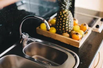 a kitchen sink with a pineapple and a bowl of fruit at MAREA Hotel in Vilanova i la Geltrú
