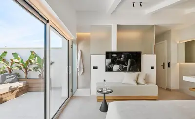 a bedroom with a bed and a couch at Hotel restaurant Ceferino in Vilanova i la Geltrú