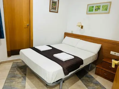 a bed with two pillows on it in a room at Hostal Mont Thabor in Barcelona