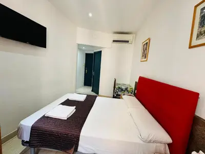 a bedroom with a large bed with a red headboard at Hostal Mont Thabor in Barcelona