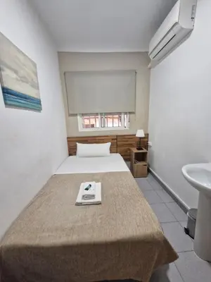 a bed in a room with a sink and a bed sidx sidx sidx at Hostal Elkano in Barcelona