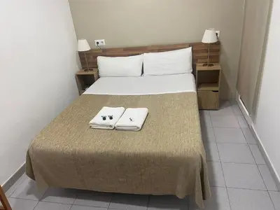 a bedroom with a bed with two towels on it at Hostal Elkano in Barcelona
