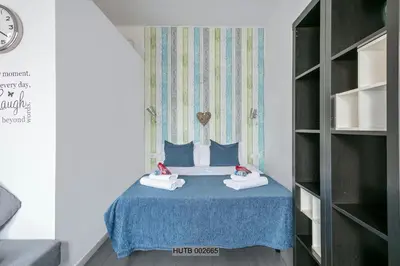 a small room with a bed with a blue table at Alcam Pau Claris in Barcelona