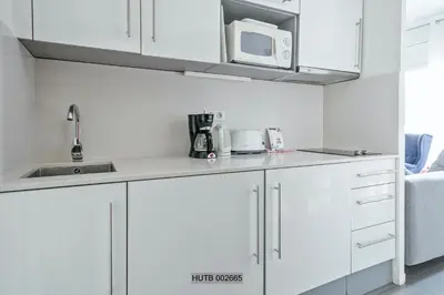 a white kitchen with a sink and a microwave at Alcam Pau Claris in Barcelona