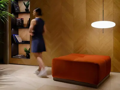 a woman walking in a room next to a orange ottoman at Musik Boutique Hotel - Solo Adultos in Barcelona