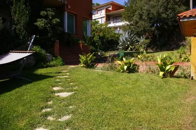 a yard with a house and some grass and a building at B&B Inés in Sant Cugat del Vallès